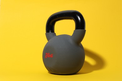 Photo of One kettlebell on yellow background. Sport equipment