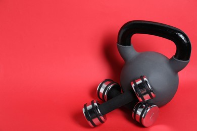 Photo of Kettlebell and dumbbells on red background. Space for text