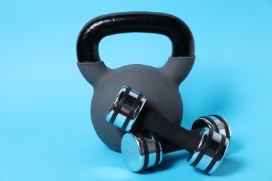 Photo of Kettlebell and dumbbells on light blue background