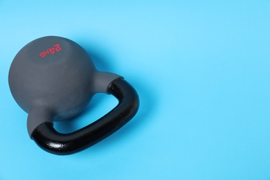 Photo of One kettlebell on light blue background. Space for text