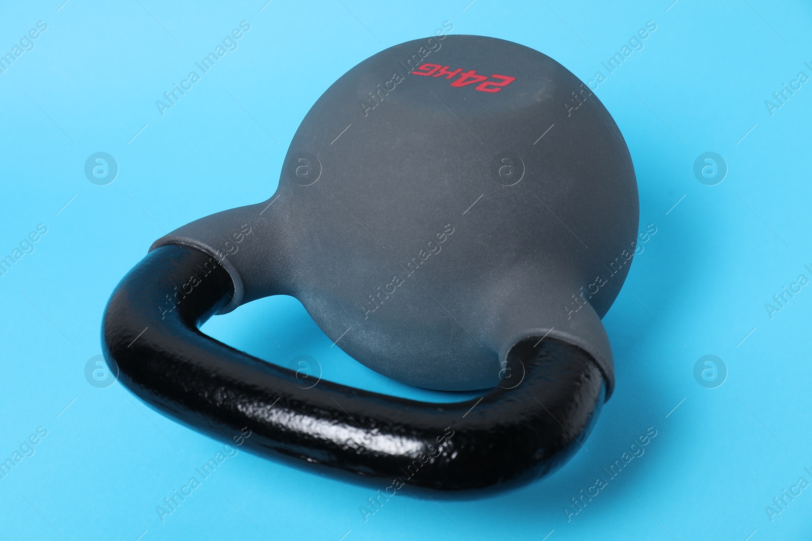 Photo of One kettlebell on light blue background, closeup