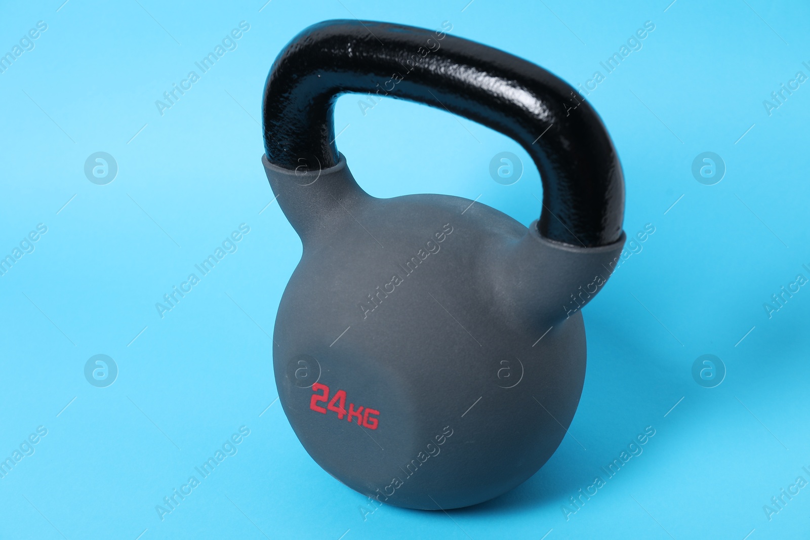 Photo of One kettlebell on light blue background. Sport equipment