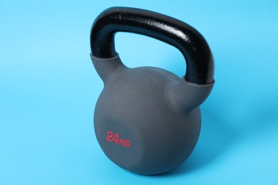 Photo of One kettlebell on light blue background. Sport equipment