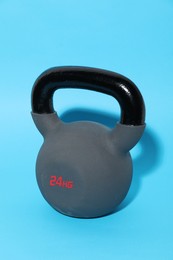 Photo of One kettlebell on light blue background. Sport equipment