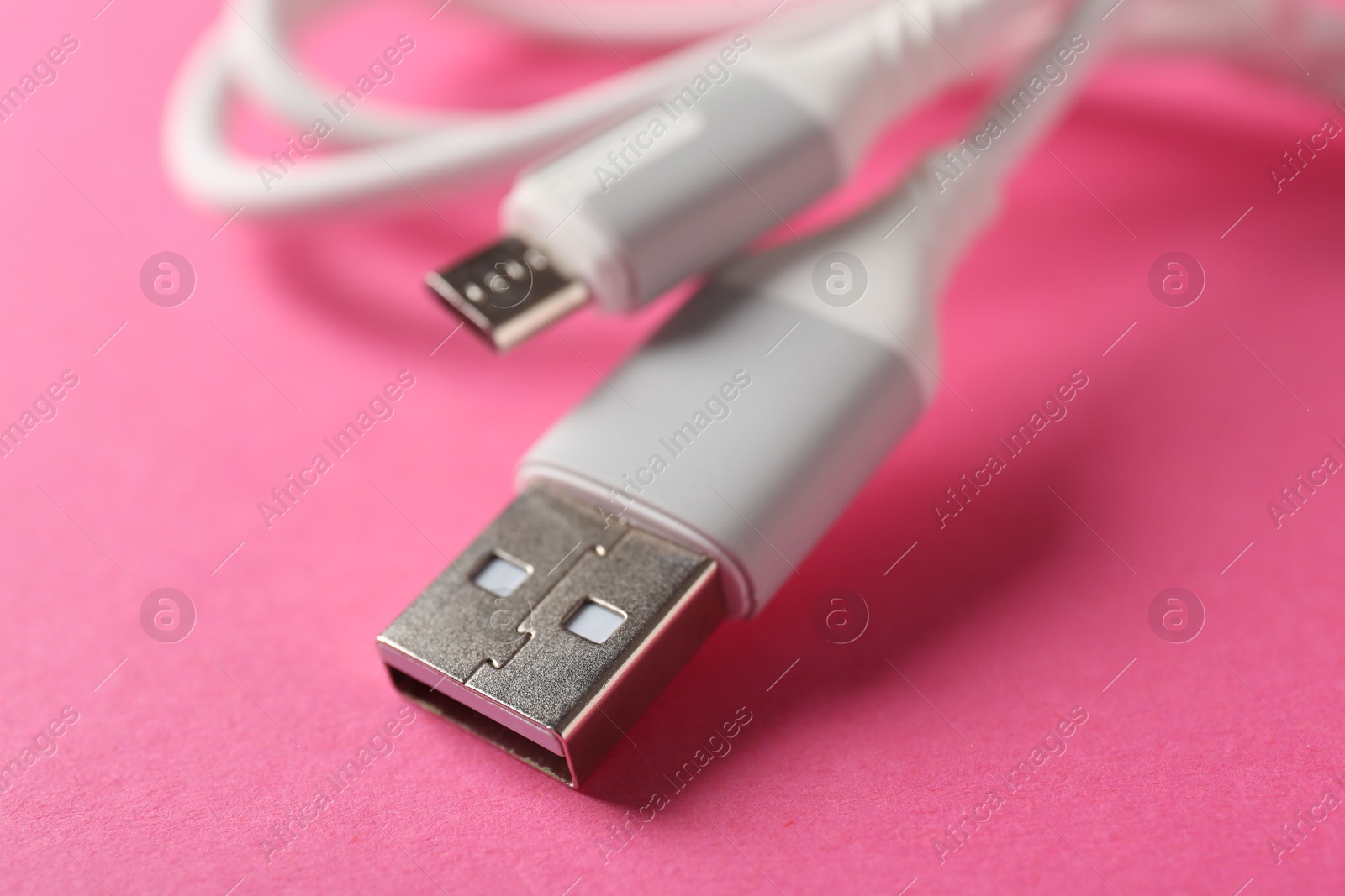 Photo of USB charge cable on pink background, closeup