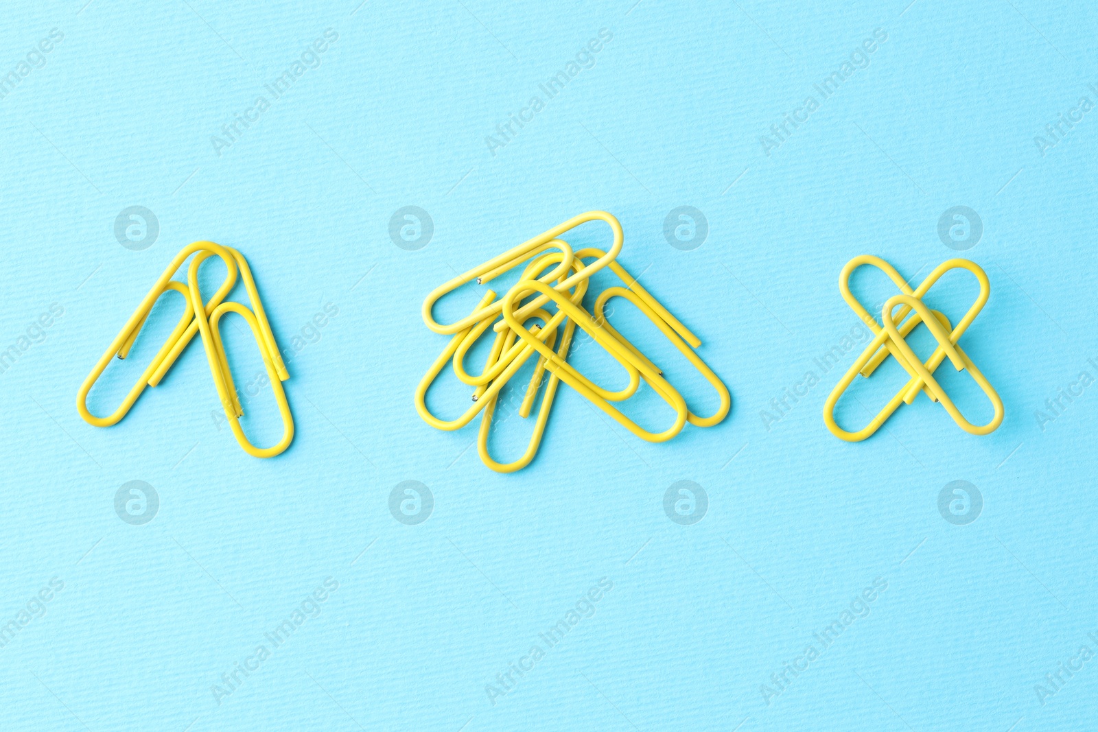 Photo of Many paper clips on light blue background, flat lay