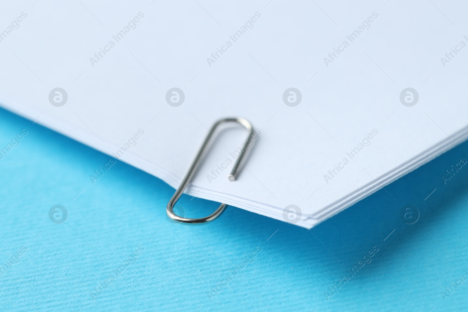 Photo of Paper notes with clip on light blue background