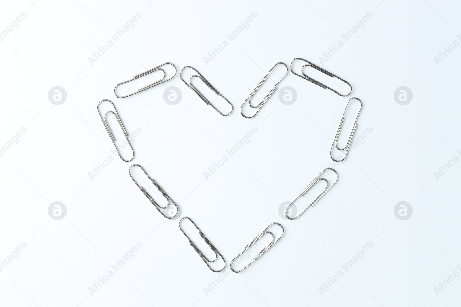 Photo of Heart made with paper clips on white background, top view