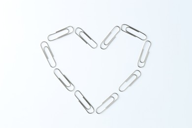 Photo of Heart made with paper clips on white background, top view