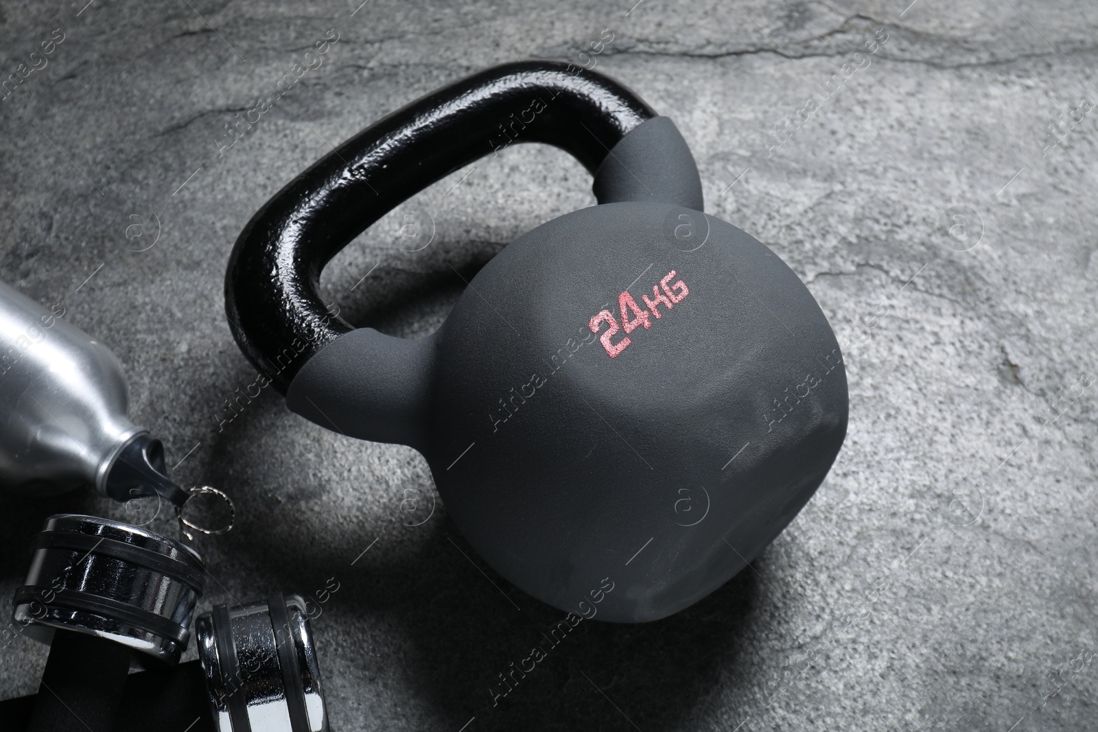 Photo of Kettlebell and dumbbells on grey background, closeup