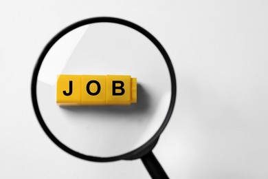 Image of Job search concept. Word made with cubes on white background, view through magnifying glass