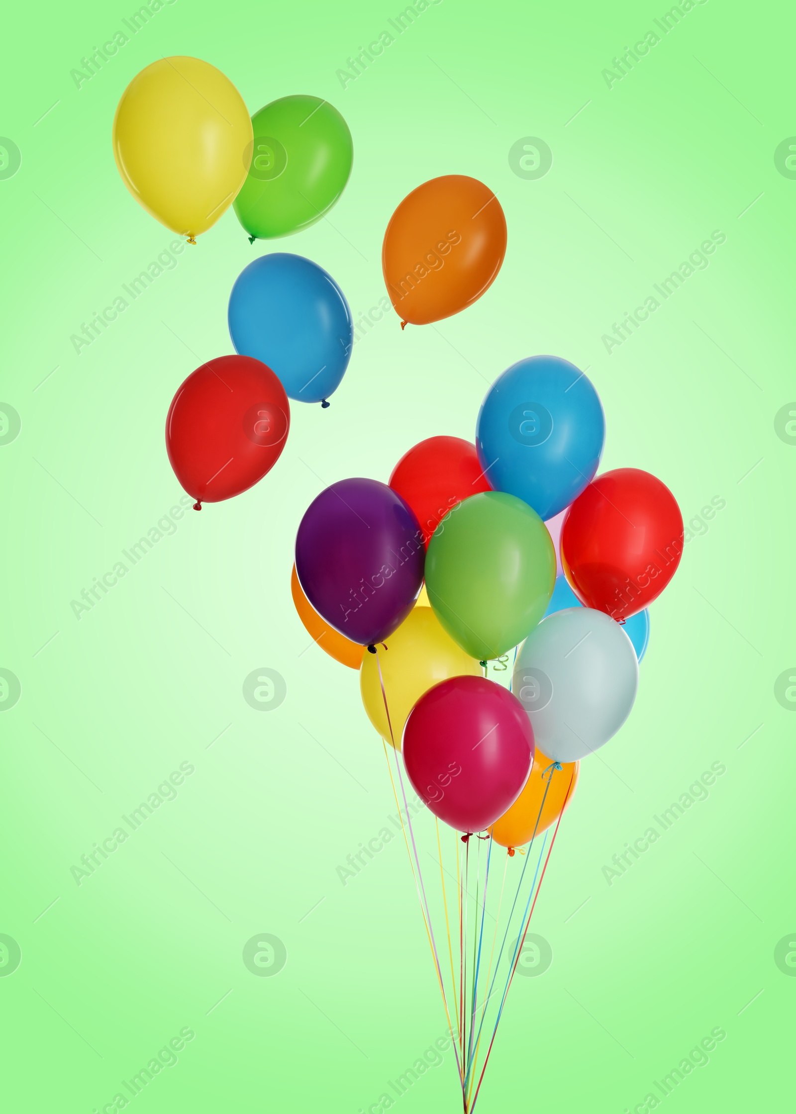 Image of Many colorful balloons in air on light green background. Birthday or other party decoration