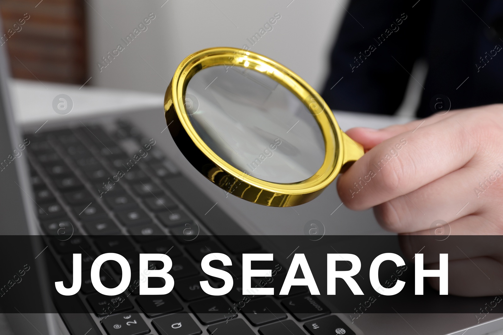 Image of Job search concept. Man holding magnifying glass near laptop, closeup