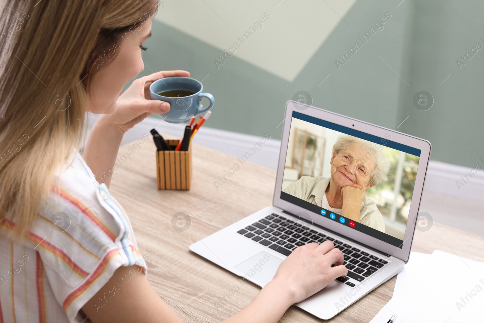 Image of Grandmother and granddaughter talking via video call on laptop. Woman using computer at home