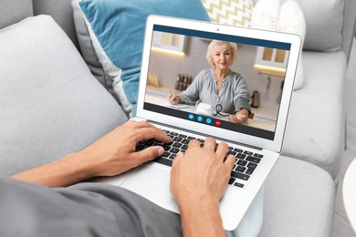 Image of Grandmother and grandson talking via video call on laptop. Man using computer at home, closeup