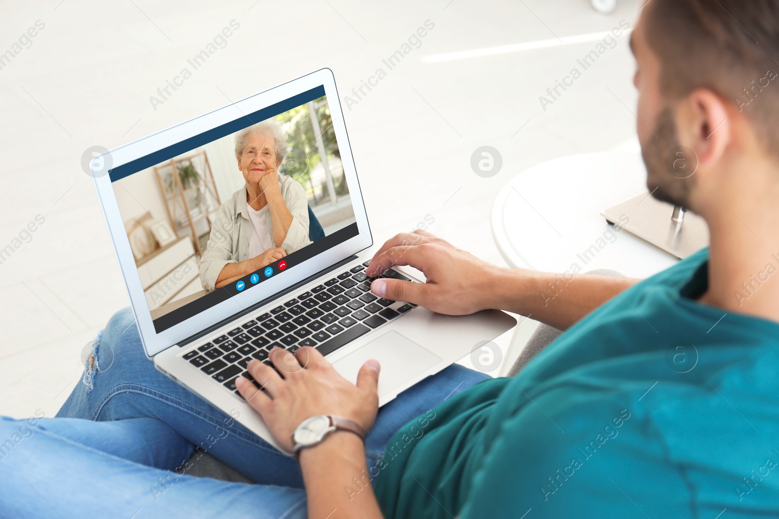 Image of Grandmother and grandson talking via video call on laptop. Man using computer at home