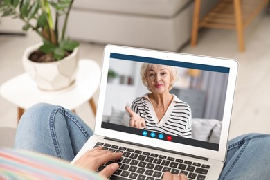 Image of Grandmother and granddaughter talking via video call on laptop. Woman using computer at home, closeup