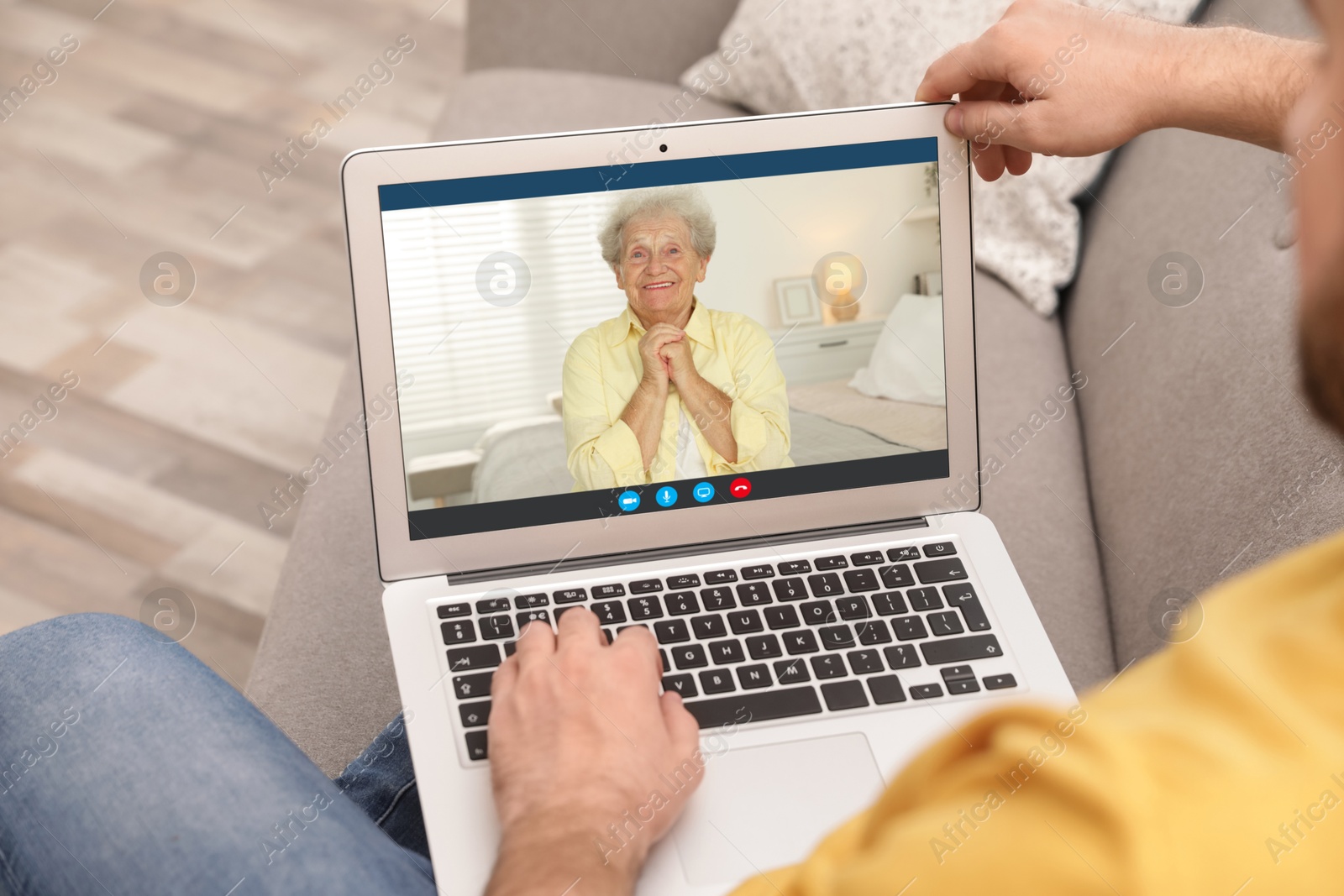 Image of Grandmother and grandson talking via video call on laptop. Man using computer at home, closeup