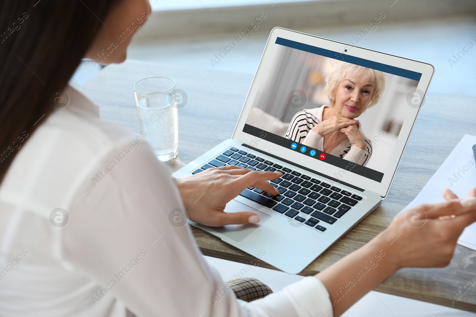 Image of Grandmother and granddaughter talking via video call on laptop. Woman using computer at table, closeup