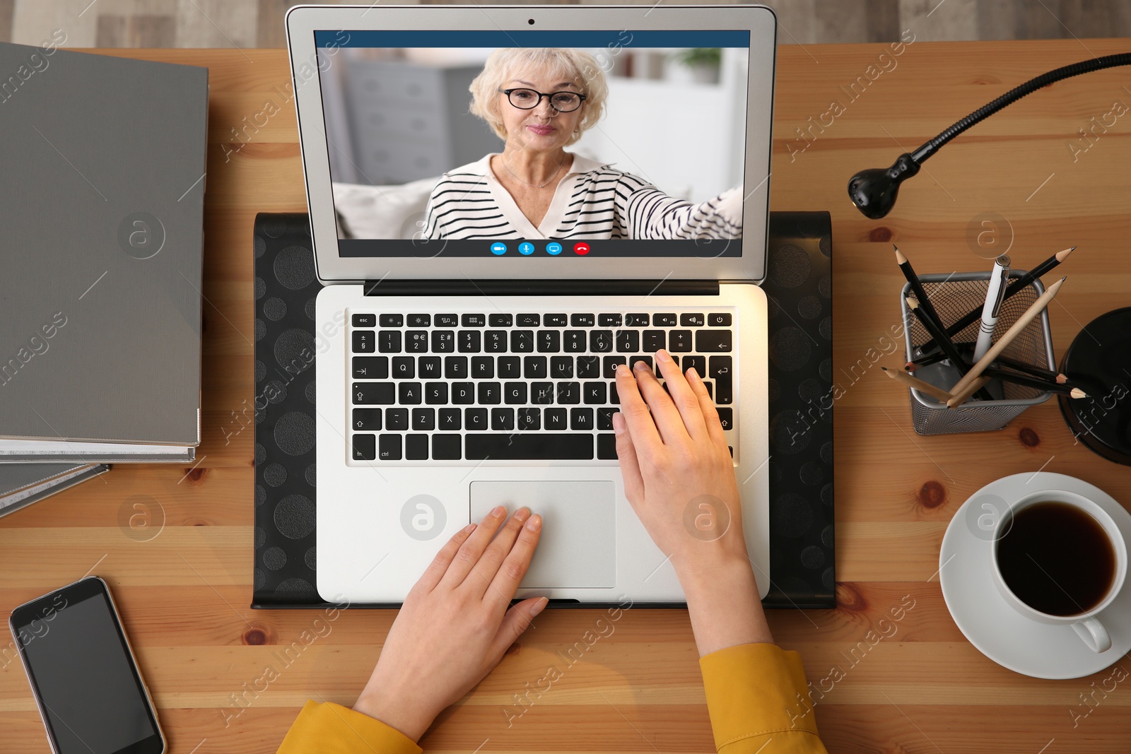 Image of Grandmother and granddaughter talking via video call on laptop. Woman using computer at table, top view