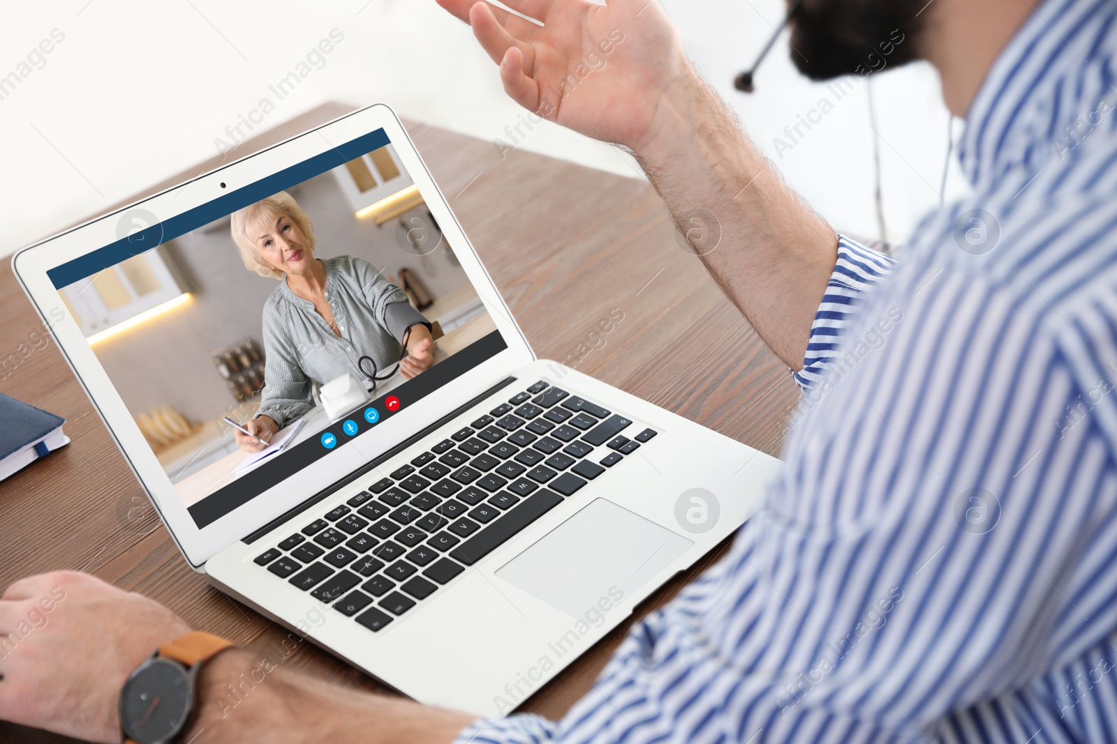 Image of Grandmother and grandson talking via video call on laptop. Man using computer at table, closeup