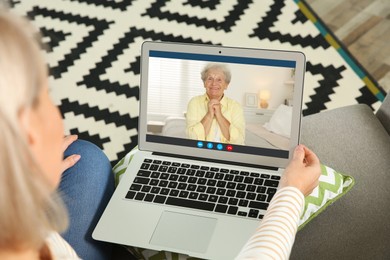 Image of Grandmother and granddaughter talking via video call on laptop. Woman using computer at home, closeup