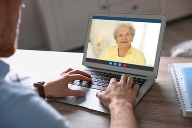 Grandmother and grandson talking via video call on laptop. Man using computer at home, closeup