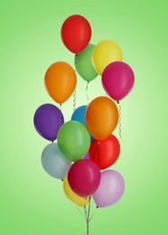 Image of Many colorful balloons in air on light green background. Birthday or other party decoration