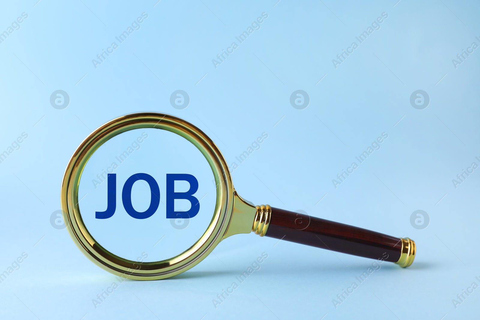 Image of Job search concept. Word on light blue background, view through magnifying glass