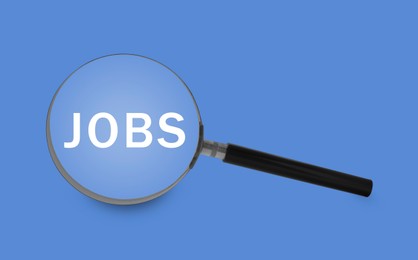 Image of Job search concept. Word on blue background, view through magnifying glass