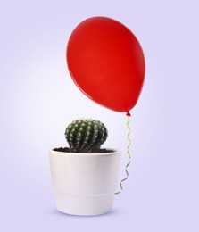 Image of Prickly cactus and red balloon on lavender color background