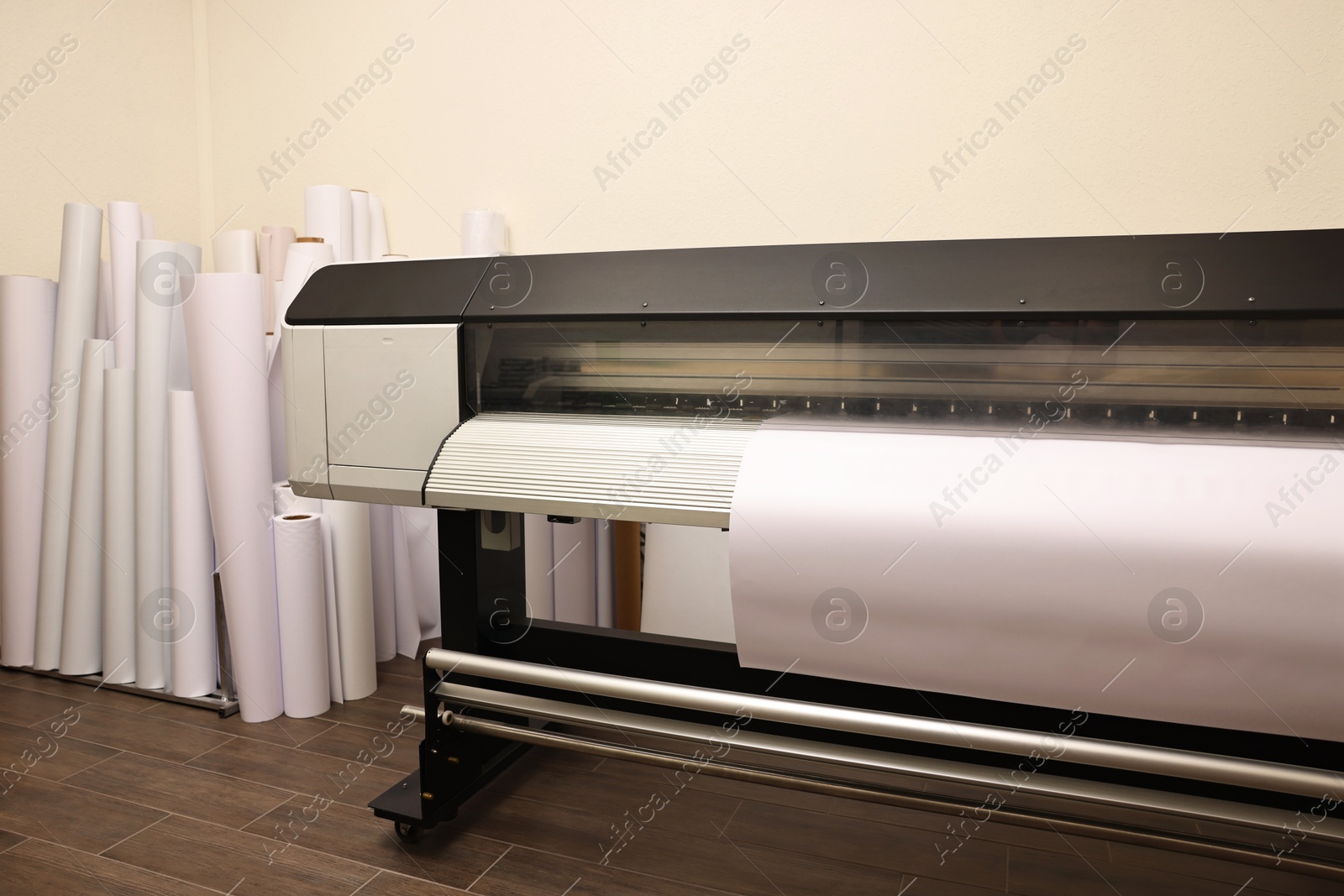 Photo of Wide-format printer with paper indoors. Printing house