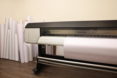 Photo of Wide-format printer with paper indoors. Printing house