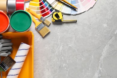 Photo of Different painter's tools on grey marble table, flat lay with space for text. Decorating and design