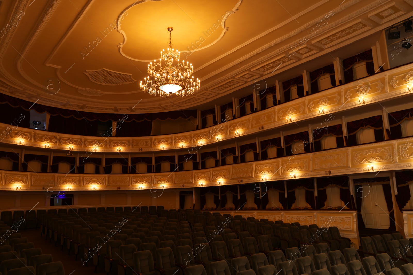 Photo of Rows of comfortable seats and beautiful chandelier in theatre