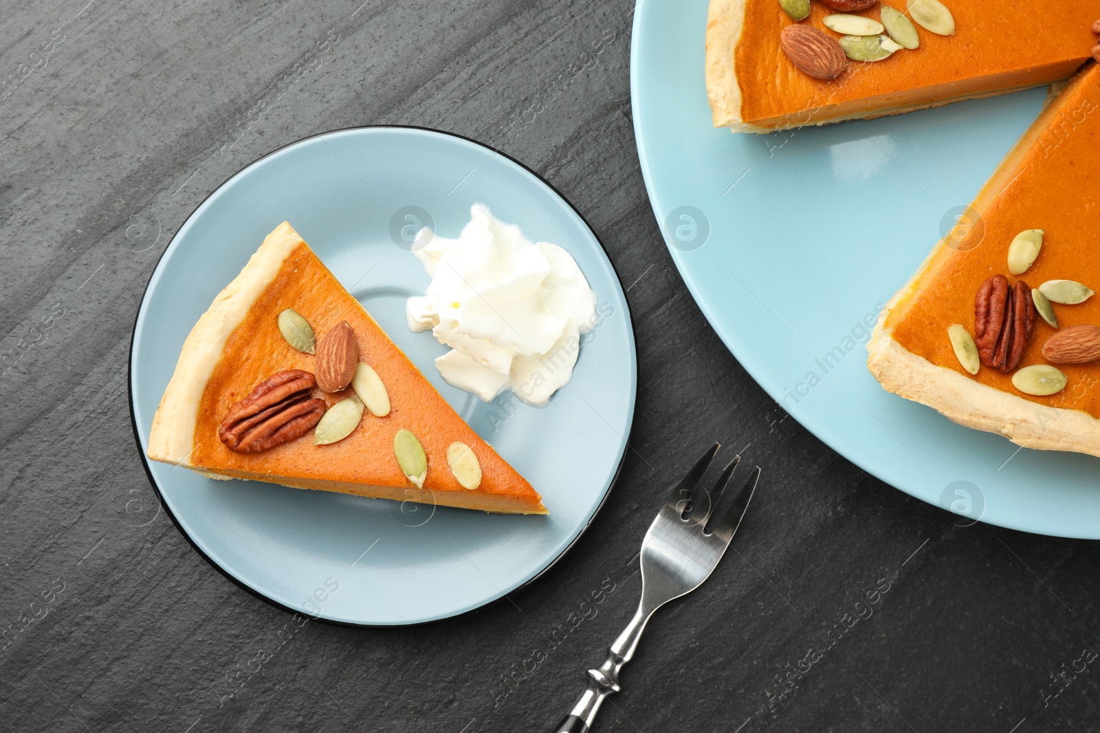 Photo of Tasty homemade pumpkin pie served on black table, top view