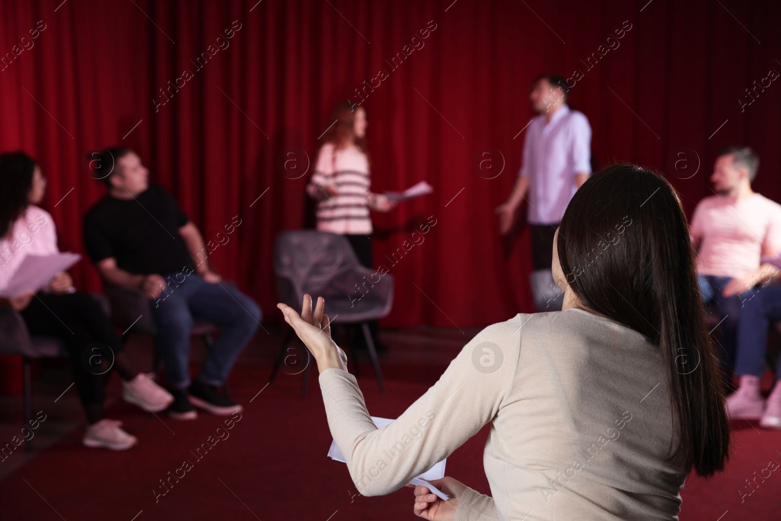 Photo of Professional actors with their scripts rehearsing in theatre