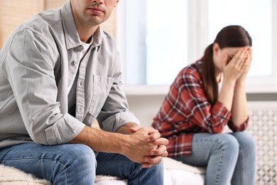 Photo of Offended couple ignoring each other at home, selective focus