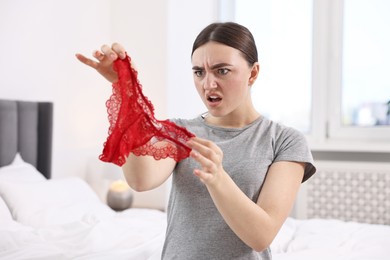 Photo of Surprised wife finding mistress panties in bedroom