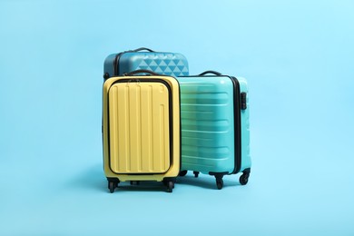 Photo of Many colorful suitcases on light blue background