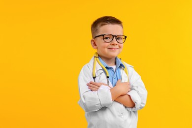 Photo of Little boy with stethoscope pretending to be doctor on yellow background. Dreaming of future profession