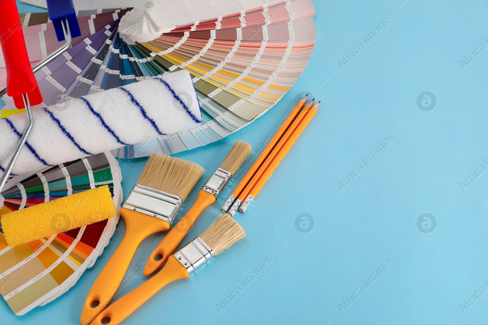 Photo of Different painter's tools on light blue table, space for text. Decorating and design