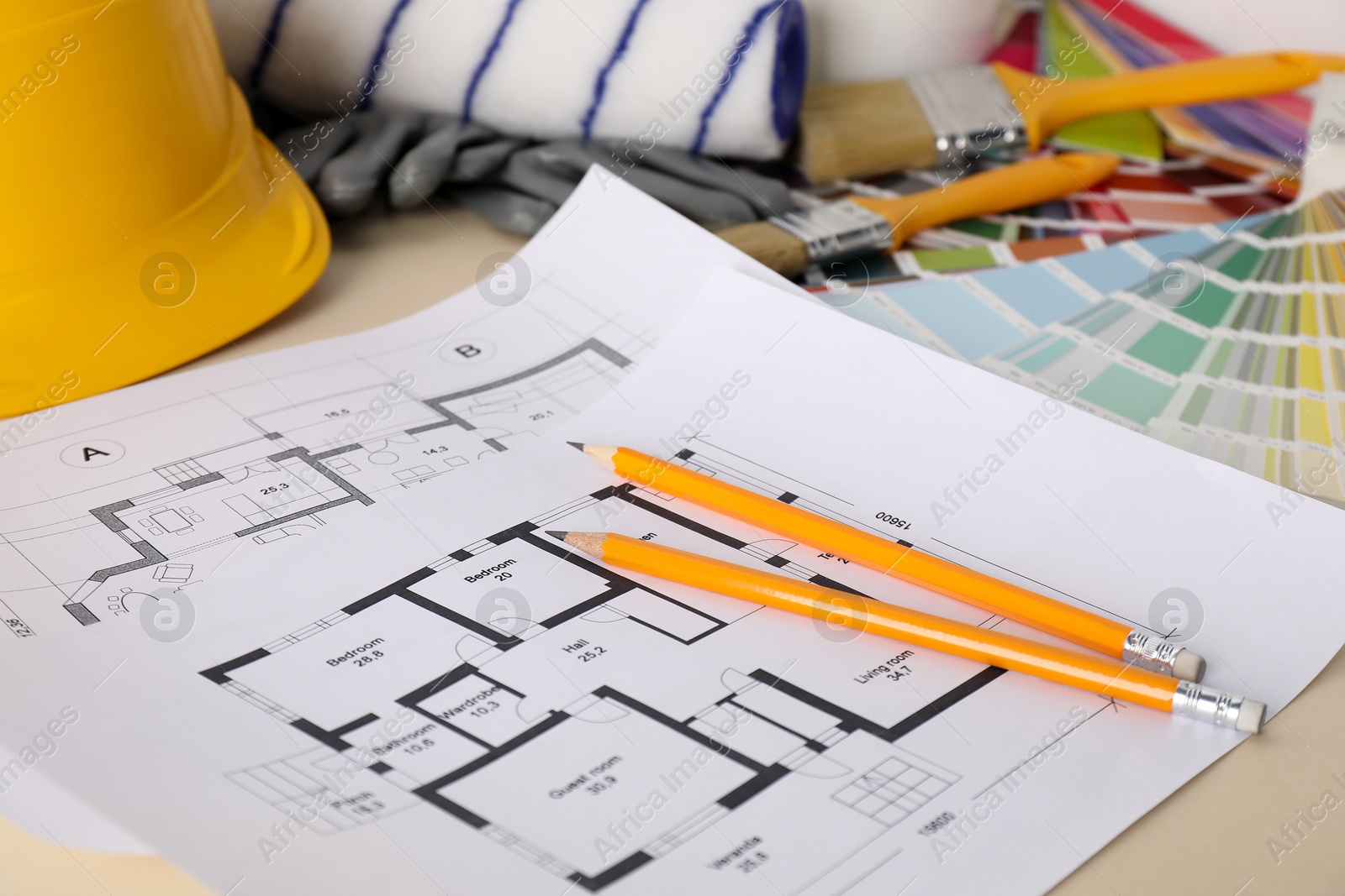 Photo of House plans and different decorator's tools on beige table, closeup