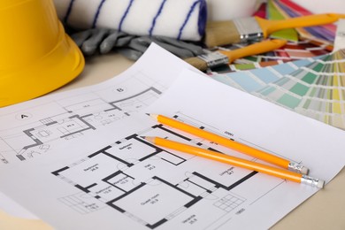 Photo of House plans and different decorator's tools on beige table, closeup