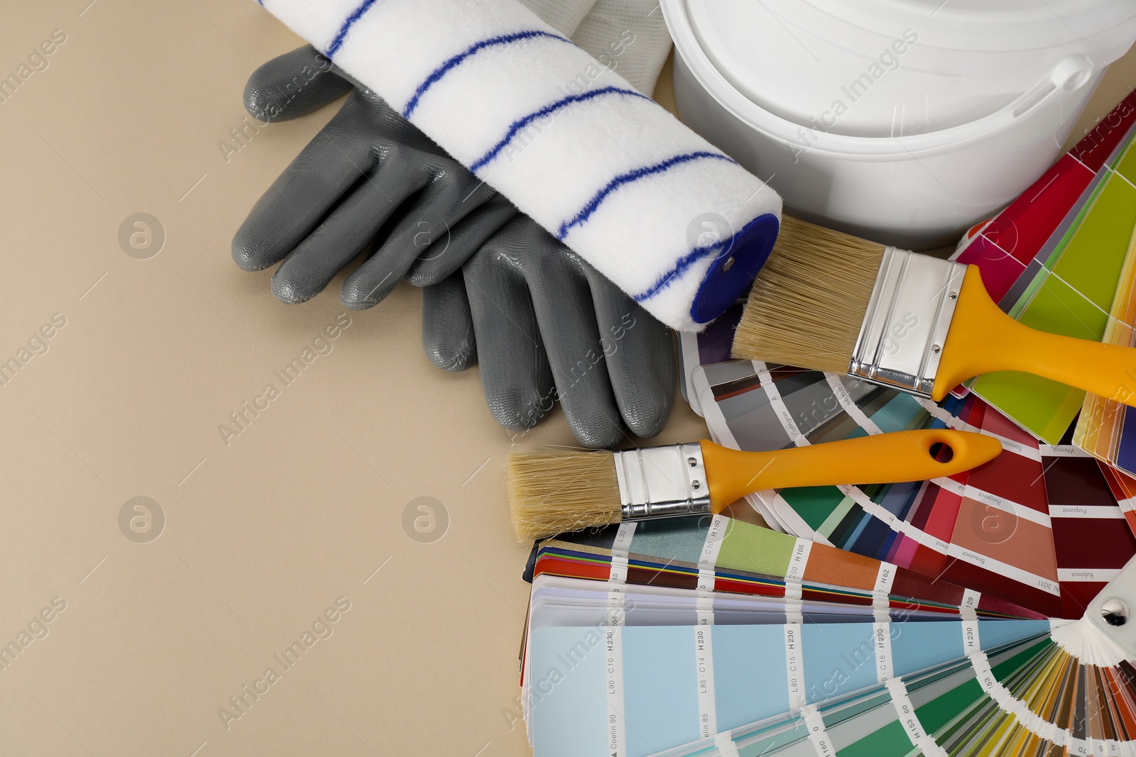 Photo of Different painter's tools on beige table, space for text. Decorating and design