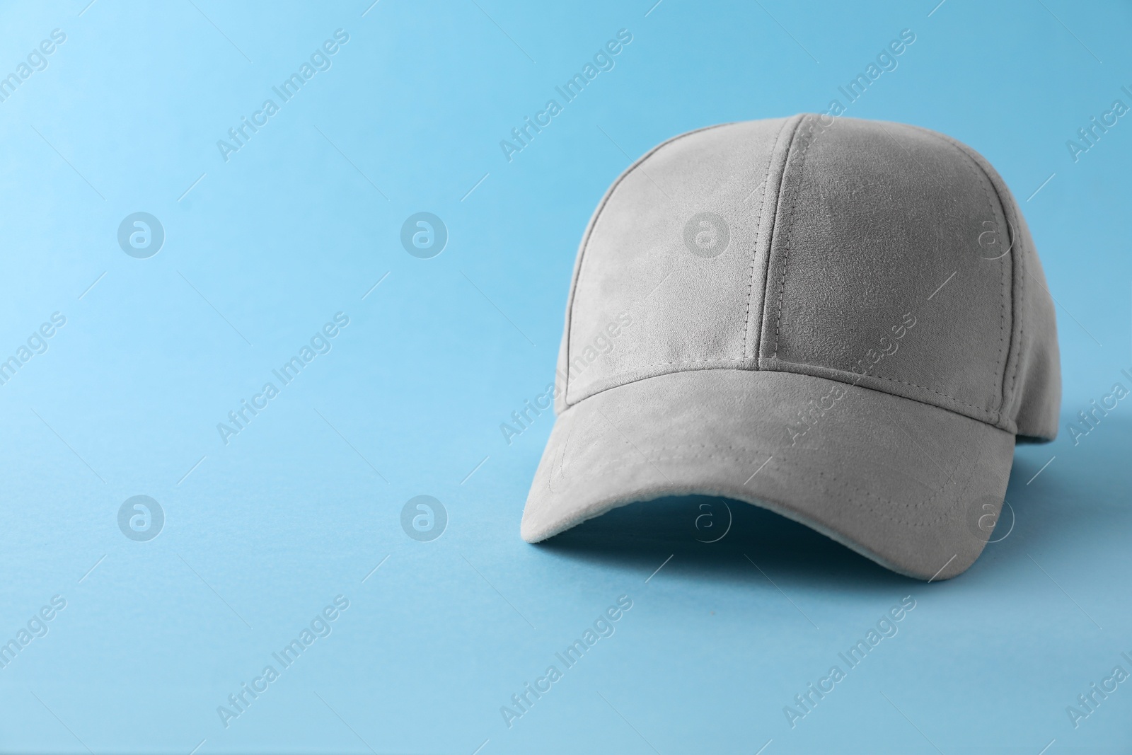 Photo of Stylish baseball cap on light blue background. Mockup for design