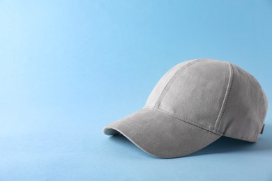 Photo of Stylish baseball cap on light blue background. Mockup for design