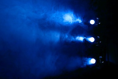 Photo of Professional spotlights and smoke on stage in theatre