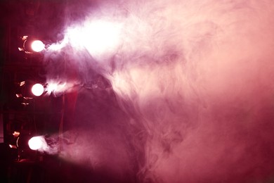 Photo of Professional spotlights and smoke on stage in theatre