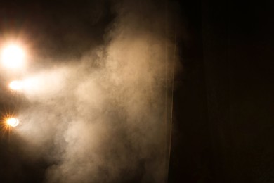 Photo of Professional spotlights and smoke on stage in theatre